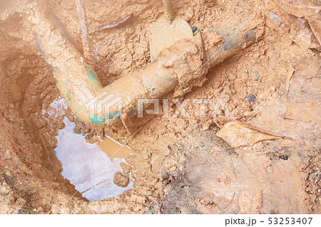 broken pipe in hole with water motion at roadside 53253407