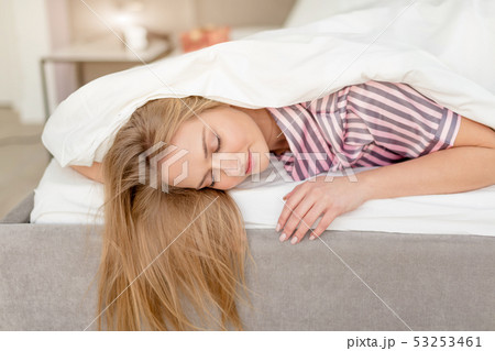 Young beautiful woman with long fair lying in bed in the morning Young beautiful woman with long fair lying in bed in the morning 53253461