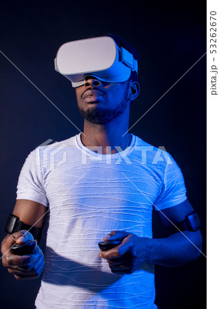 African Man in white, wearing VR Headset on green blue dual color background. African Man in white, wearing VR Headset on green blue dual color background. 53262670
