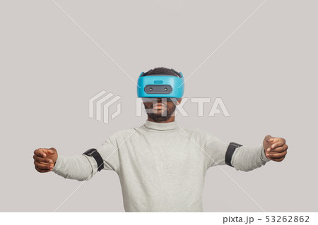Young african man wearing virtual reality goggles isolated on white background Young african man wearing virtual reality goggles isolated on white background 53262862