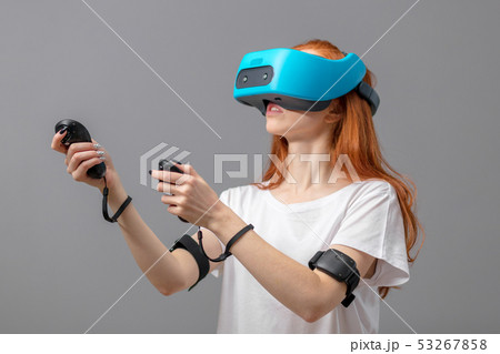 Redhead girl using VR glasses isolated over white. Virtual reality experience Redhead girl using VR glasses isolated over white. Virtual reality experience 53267858