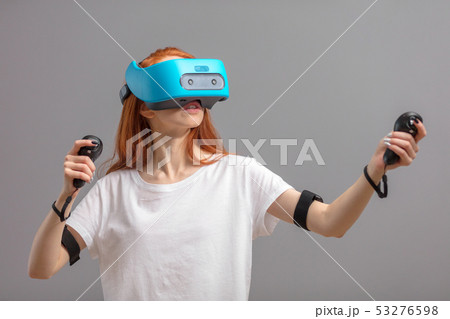 Redhead girl using VR glasses isolated over white. Virtual reality experience Redhead girl using VR glasses isolated over white. Virtual reality experience 53276598