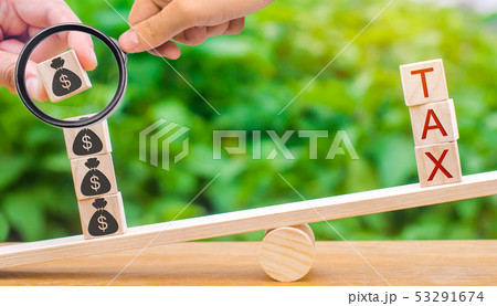 A hand puts wooden blocks with dollars on scales A hand puts wooden blocks with dollars on scales 53291674