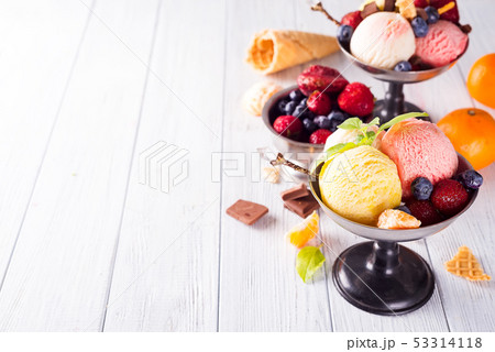 Set of ice cream scoops of different colors and flavours with berries, chocolate on wooden Set of ice cream scoops of different colors and flavours with berries, chocolate on wooden 53314118
