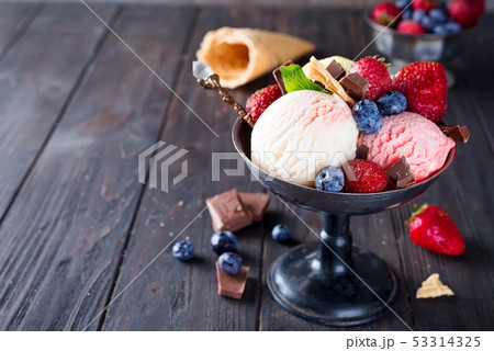 Set of ice cream scoops of different colors and flavours with berries, chocolate on dark background Set of ice cream scoops of different colors and flavours with berries, chocolate on dark background 53314325