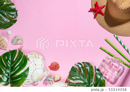 Vacation travel equipment Straw hat, palm leaves and marine objects, shells, starfish On a pink 53314356