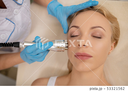 Blonde woman enjoying face procedures visiting cosmetologist Blonde woman enjoying face procedures visiting cosmetologist 53321562
