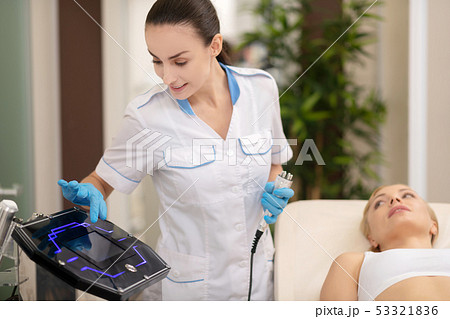 Dermatologist providing ultrasound skin treatment for client 53321836