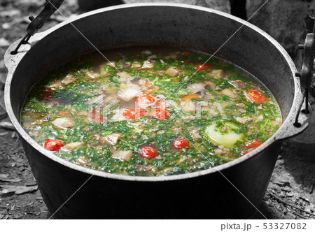 Freshly cooked hot soup in sooty cauldron on camp 53327082