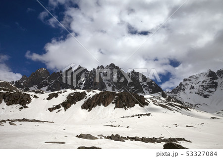 High sunlit rocks, snowy plateau and cloudy sky High sunlit rocks, snowy plateau and cloudy sky 53327084