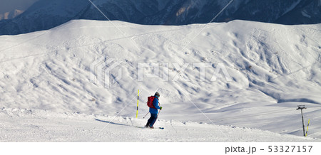 Skier downhill on snowy ski slope in sun winter 53327157
