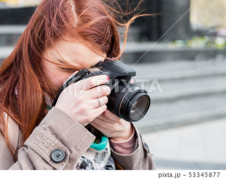 attractive young woman talking pictures outdoors. Sunny spring afternoon. 53345877