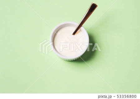 Bowl of natural yogurt on pastel green 53356800