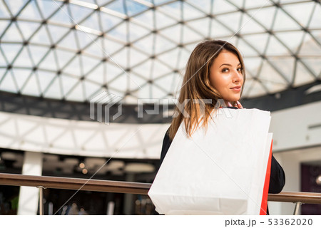Beatiful dark-haired girl with a shopping bag at the mall 53362020