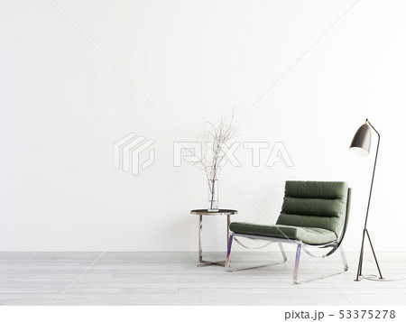 Green armchair and metal table on empty wall in 53375278