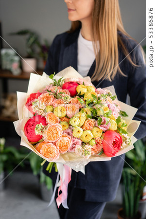 Beautiful bouquet of mixed flowers in woman hand. Floral shop concept . Beautiful fresh cut bouquet 53386876