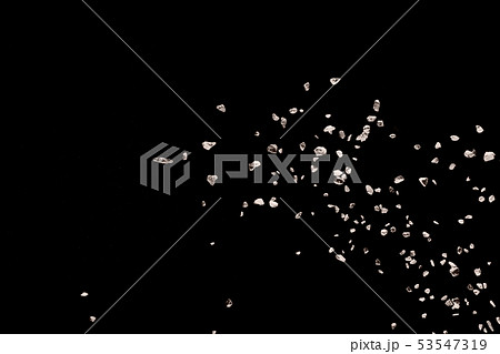 Split debris of stone exploding against black 53547319