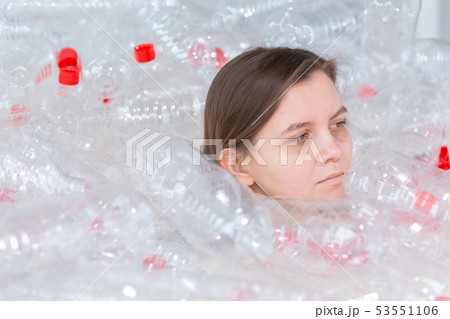 Dehydrated sick woman is lying in a pile of plastic bottles. Environmental pollution problem. Stop Dehydrated sick woman is lying in a pile of plastic bottles. Environmental pollution problem. Stop 53551106