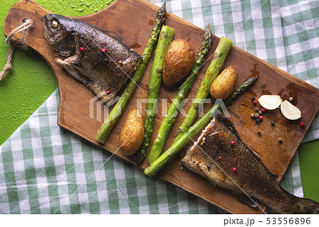 Baked fish with vegetables on a cutting board 53556896