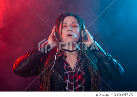 Meloman, music and people concept - young woman with dreadlocks listen to the music and enjoy it Meloman, music and people concept - young woman with dreadlocks listen to the music and enjoy it 53584470