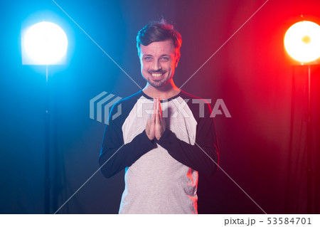 Gesture and emotions concept - Portrait of a man over the light, folded his hands 53584701