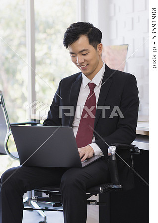 Asian Businessman using laptop in office.. Asian Businessman using laptop in office.. 53591908