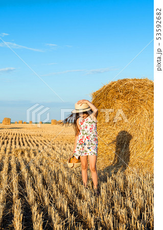 Adorable girl in rye field on sunset with a basket Adorable girl in rye field on sunset with a basket 53592682