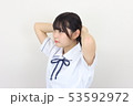 髪をまとめる制服の女子高校生 53592972
