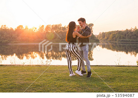 Romantic, social dance and people concept - young couple dancing bachata on the background of sunset 53594087