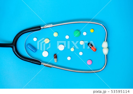 Stethoscope and pills on the blue background Stethoscope and pills on the blue background 53595114