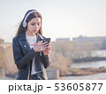 teenager girl 16 years old listening to music on headphones in phone 53605877