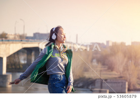 teenager girl 16 years old listening to music on headphones in phone 53605879