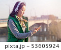 teenager girl 16 years old listening to music on headphones in the phone 53605924