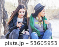 two asian girlfriends teen girls sit in the park and watch the phone, the generation of digital 53605953
