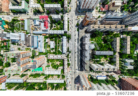Aerial city view with crossroads and roads, houses, buildings, parks and parking lots. Sunny summer 53607236