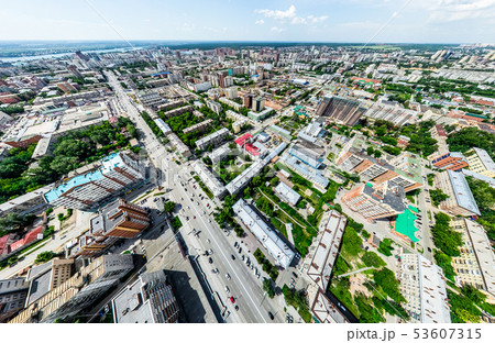 Aerial city view with crossroads and roads, houses, buildings, parks and parking lots. Sunny summer 53607315