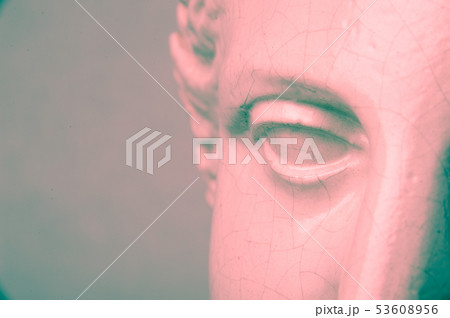 Close up face gypsum copy antique sculpture with craquelure. Red green vintage filter effect . 53608956