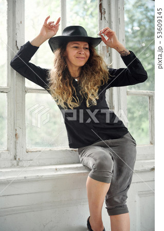 fashionable girl dressed in black shirt, hat and 53609145
