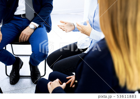 Group of people sitting in a circle during therapy. Meeting of business team participating in 53611883