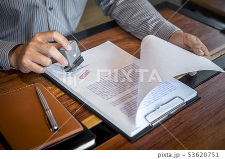 Hands of businessman stamp on paper document to 53620751