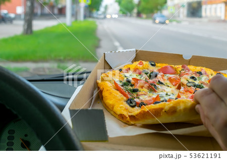 driver eats pizza in the car 53621191