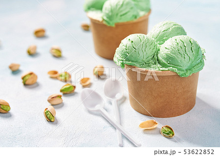 two portions pistachio ice cream in paper cup on two portions pistachio ice cream in paper cup on 53622852