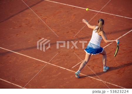 Young woman playing tennis on clay. Forehand. Young woman playing tennis on clay. Forehand. 53623224