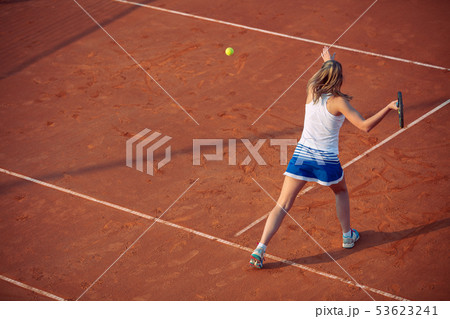 Young woman playing tennis on clay. Forehand. Young woman playing tennis on clay. Forehand. 53623241