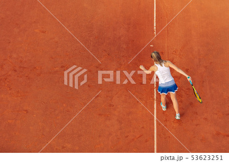 Aerial shot of a female tennis player on a court during match. Young woman playing tennis.High angle 53623251
