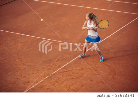 Woman playing tennis on clay court, with sporty outfit and healthy lifestyle Woman playing tennis on clay court, with sporty outfit and healthy lifestyle 53623341