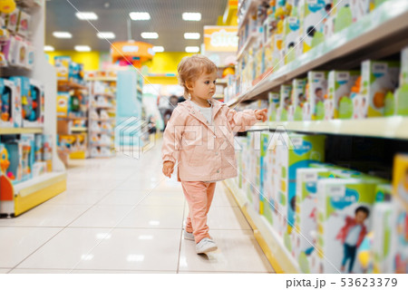 Little girl choosing toys in kids store Little girl choosing toys in kids store 53623379