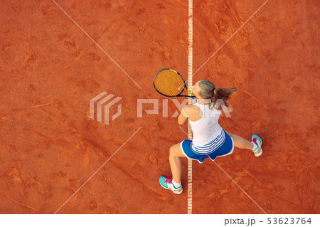 Aerial shot of a female tennis player on a court during match. Young woman playing tennis.High angle 53623764