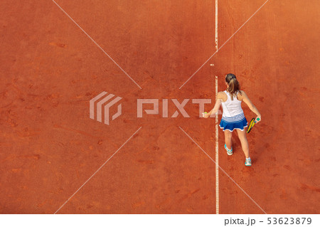 Aerial shot of a female tennis player on a court during match. Young woman playing tennis.High angle 53623879