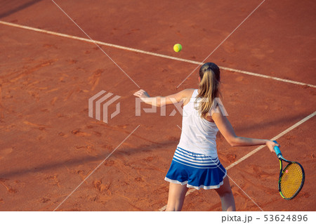 Young woman playing tennis on clay. Forehand. 53624896